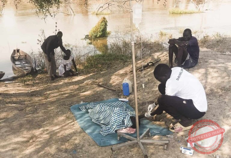 Medic treating cholera patients in the open [Photo Courtesy: WaterStep/John Dau Foundation]